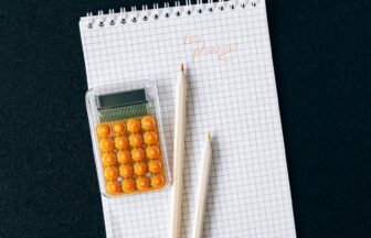 notebook and pencils on black surface