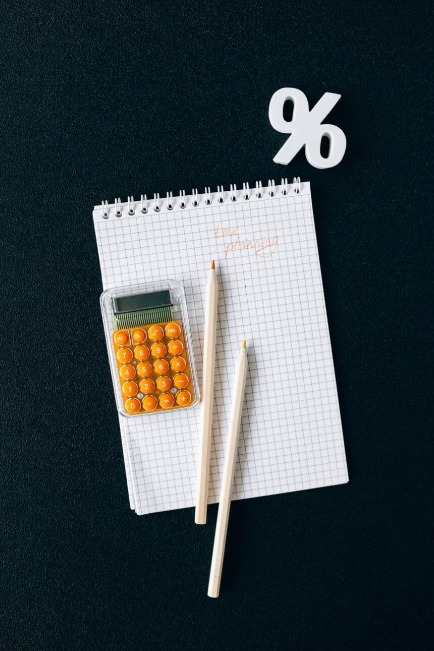 notebook and pencils on black surface