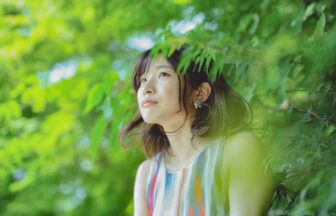 a woman in printed tank top beside green trees