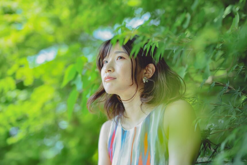 a woman in printed tank top beside green trees